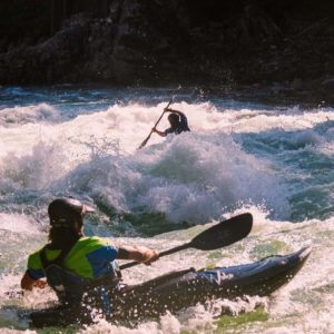 Two whitewater paddlers in Waka kayaks